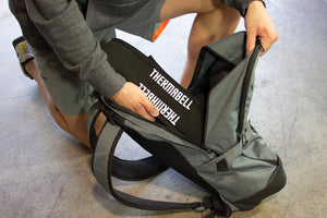 Barbell warmer placed into backpack for easy storage in cold home gym or cold garage gym